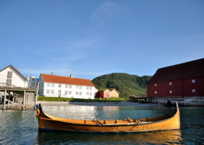 Am Ende der Woche waren wir immer im Handelsmuseum(eine Art Freilichtmuseum) Kjerringøy, welches nur ein paar hundert Meter von der Werkstatt entfernt war. Dort hatte Ulf auch noch eine kleine Werkstatt(siehe roten Pfeil), wo er den Besuchern/ Touristen in der Saison den Nordlandbootsbau anhand eines 2. etwas kleineren Bootes näherbrachte.